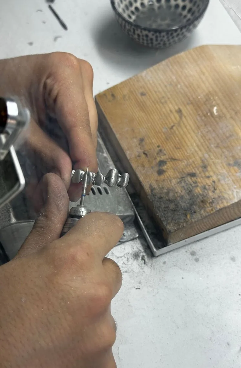作業台でリングを仕上げる職人の手
